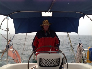 The Skipper may look grumpy but in fact he was being a sweetheart and letting me stay dry while he stoically put up with the revolting weather!